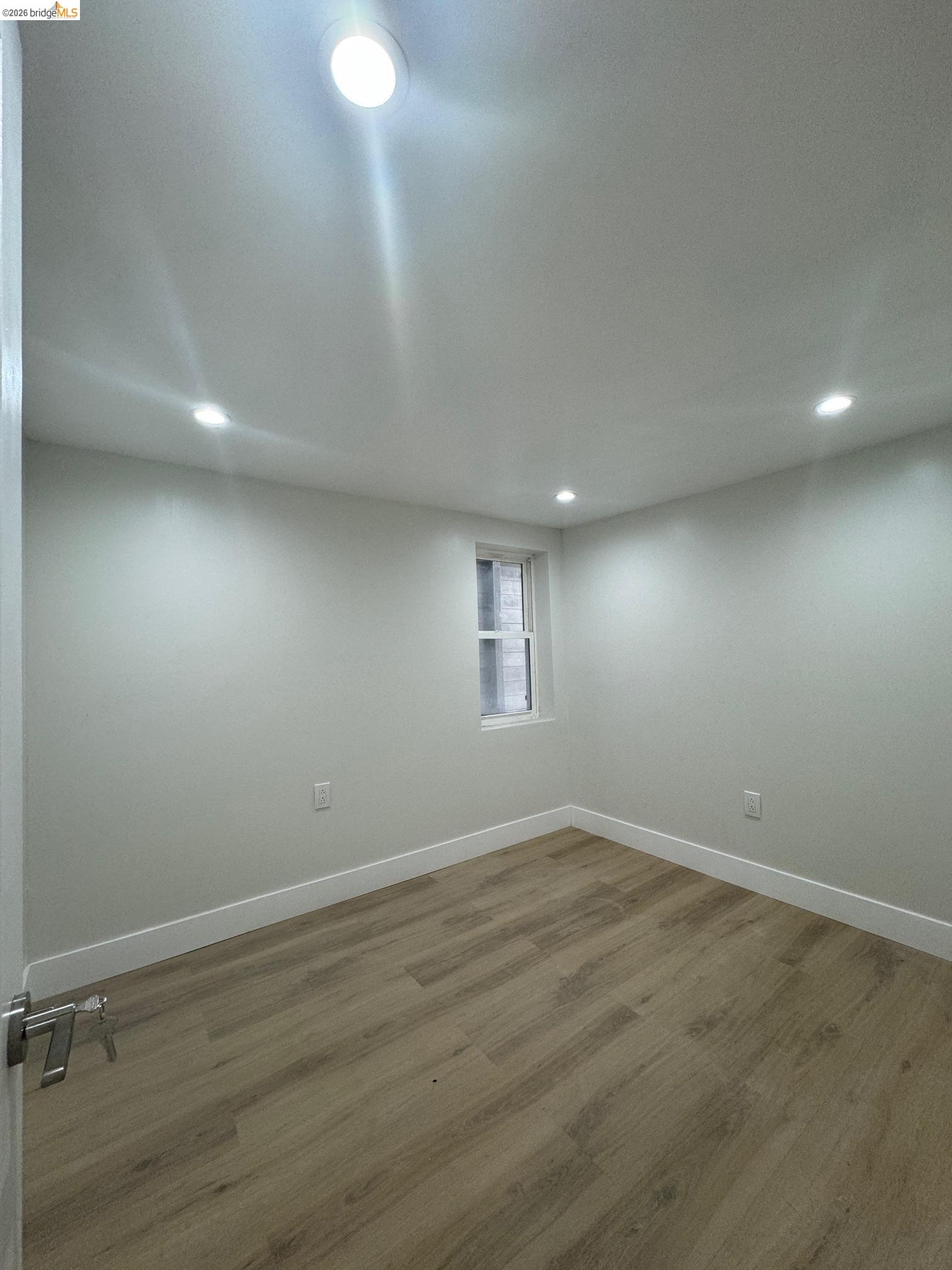 1662 14th Street Oakland, CA 94607 - Photo 50 of 57 an empty room with wooden floor and windows