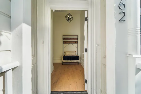 a view of a hallway with wooden floor and stairs