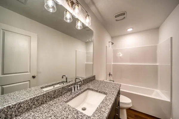 a bathroom with a tub a sink and a mirror