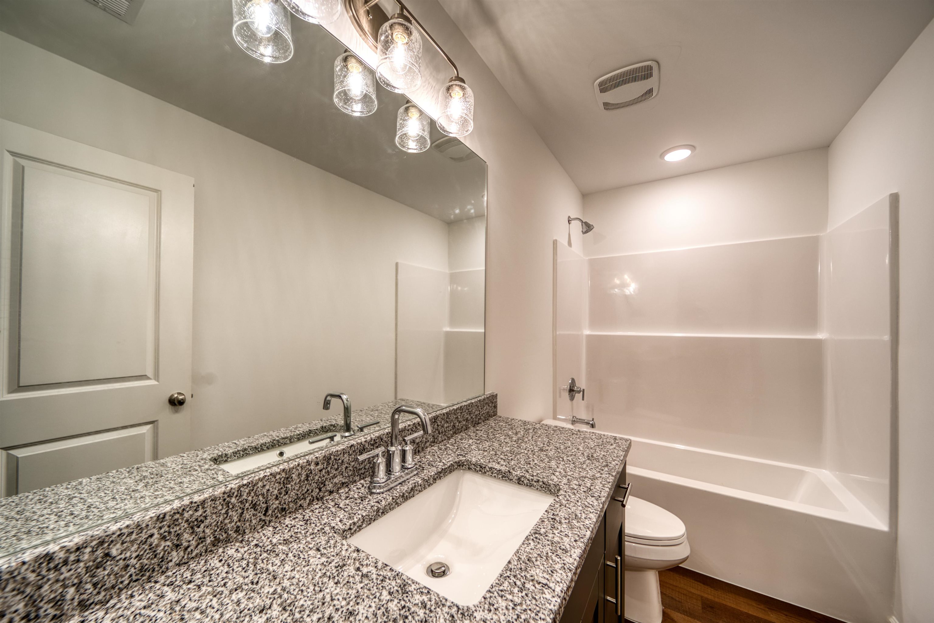 a bathroom with a tub a sink and a mirror