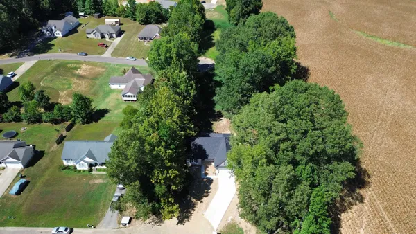 an aerial view of residential houses with outdoor space and street view