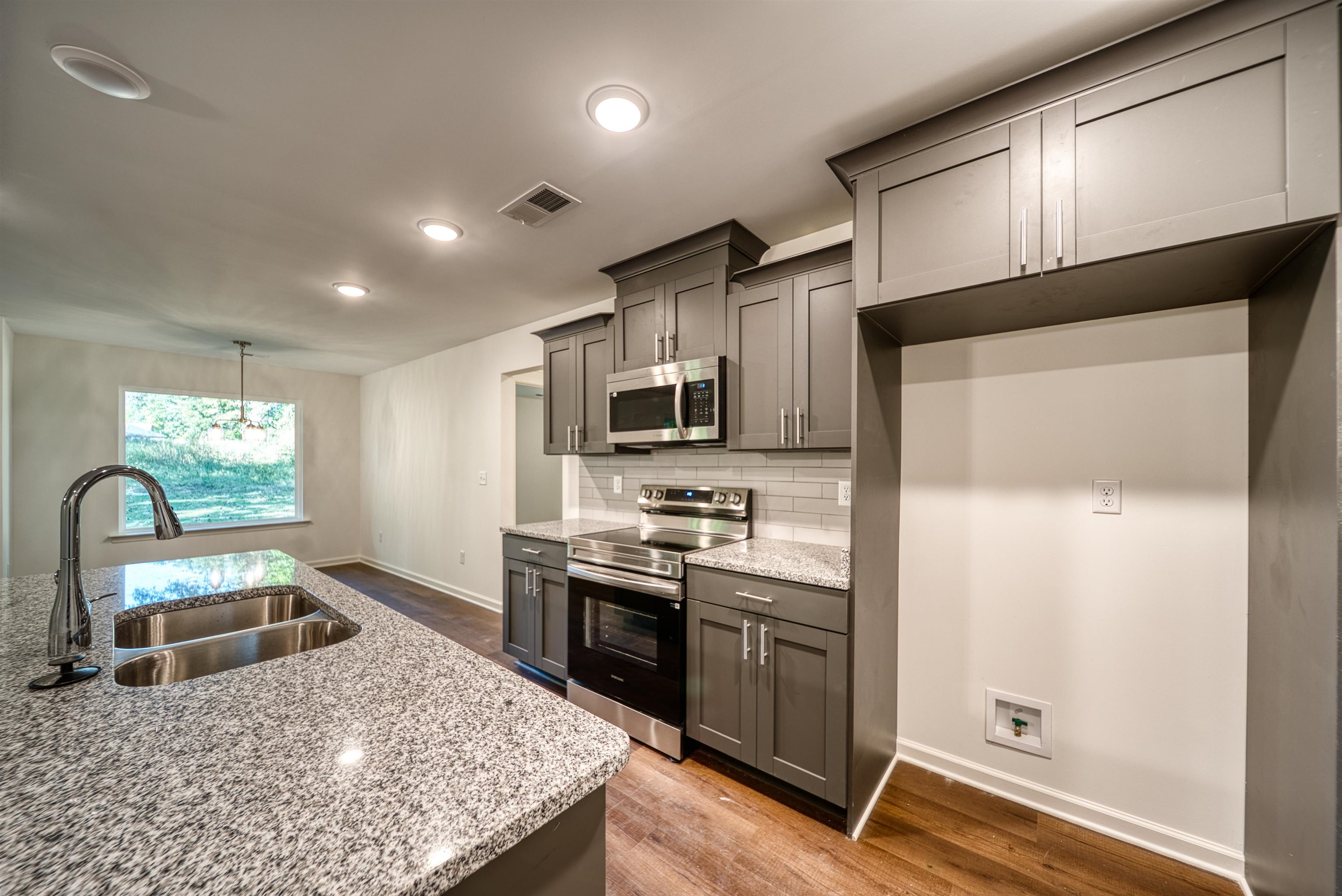 108 Walnut Ridge Ripley, TN 38063 - Photo 17 of 35 a kitchen with stainless steel appliances granite countertop a sink stove microwave and refrigerator