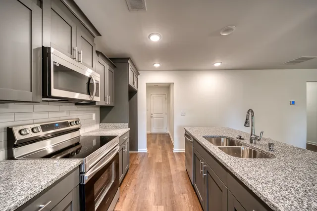 a kitchen with stainless steel appliances granite countertop a sink stove and refrigerator