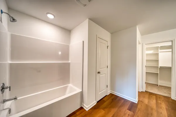 a view of a big room with wooden floor a kitchen view and a window