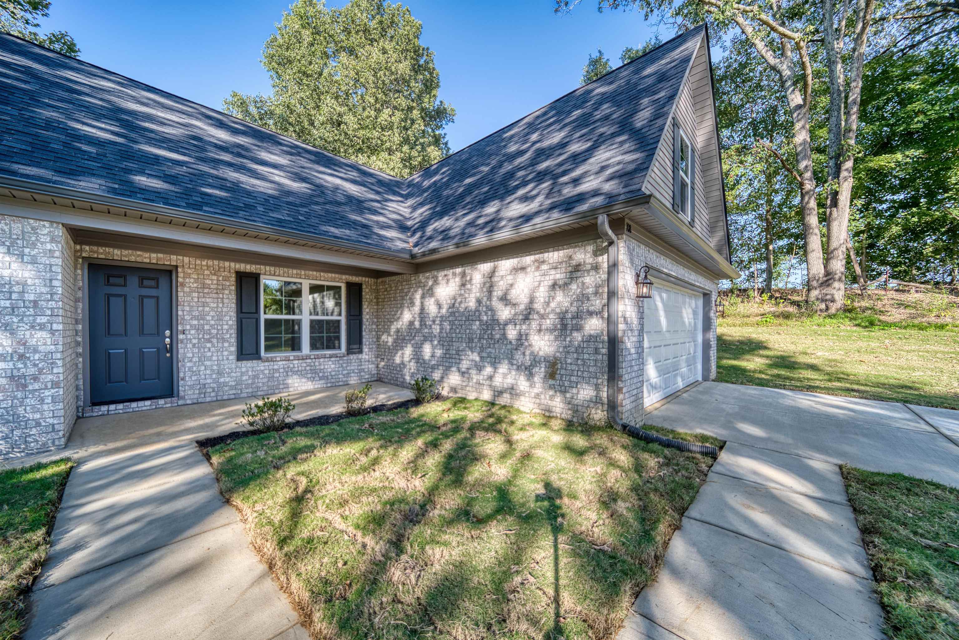 108 Walnut Ridge Ripley, TN 38063 - Photo 30 of 35 View of exterior entry with roof with shingles, a lawn, and brick siding