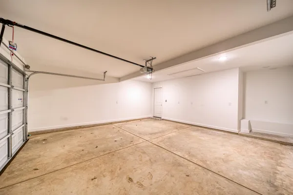 an empty room with an entryway and chandelier fan