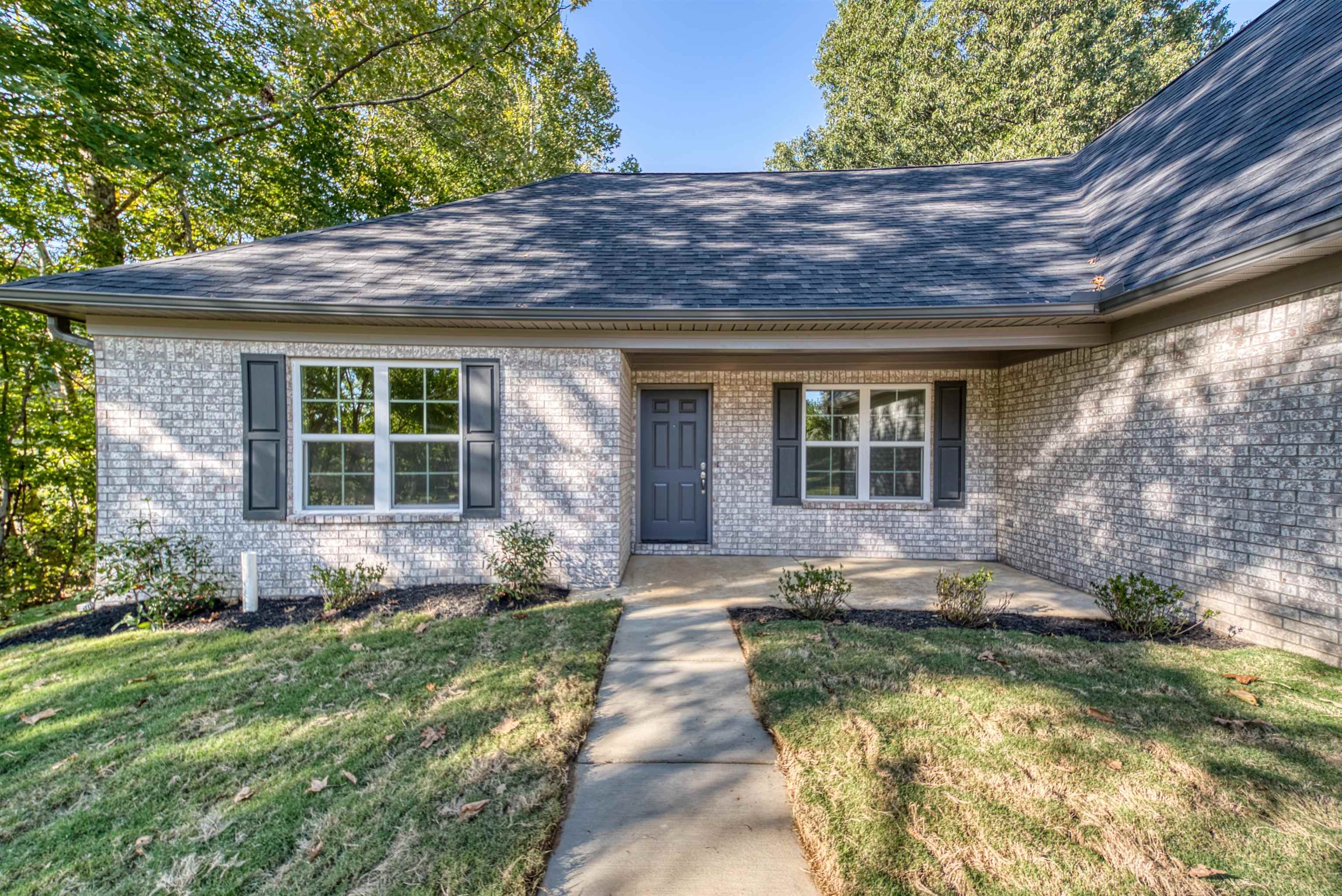 108 Walnut Ridge Ripley, TN 38063 - Photo 8 of 35 Doorway to property featuring a shingled roof, a lawn, covered porch, and brick siding