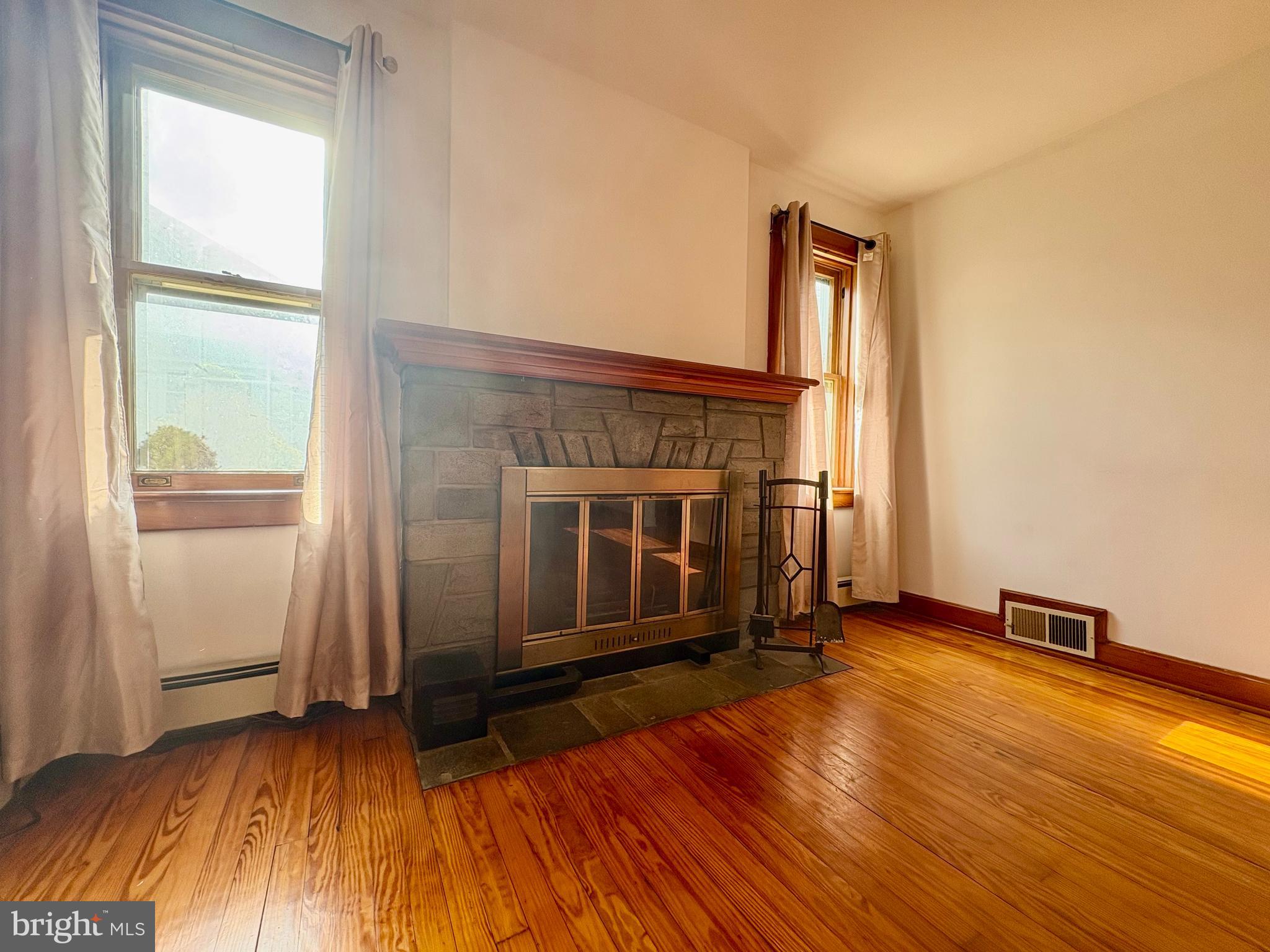 424 Lampeter Road Lancaster, PA 17602 - Photo 14 of 41 an empty room with wooden floor a fireplace and windows