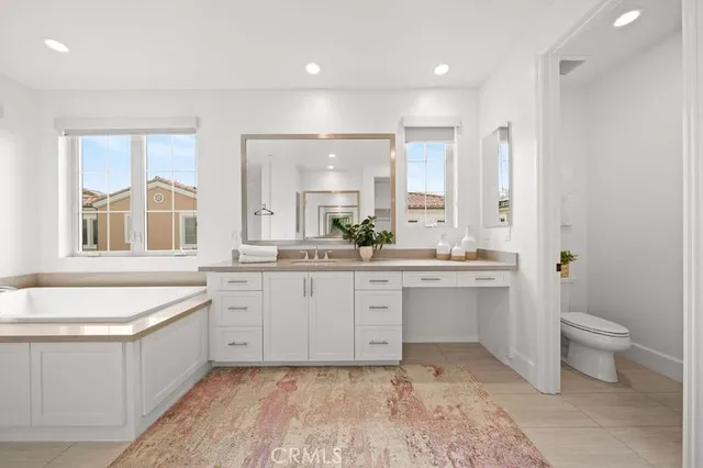 a large bathroom with a double vanity sink a large mirror and a bathtub