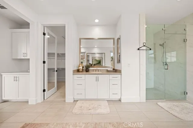 a bathroom with a sink shower and a mirror