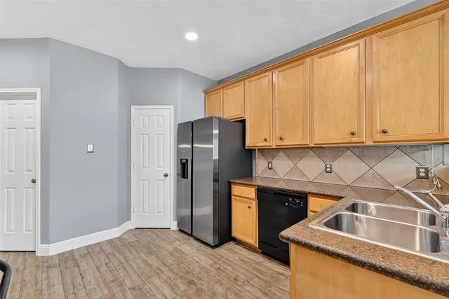 a kitchen with stainless steel appliances granite countertop a refrigerator and a sink