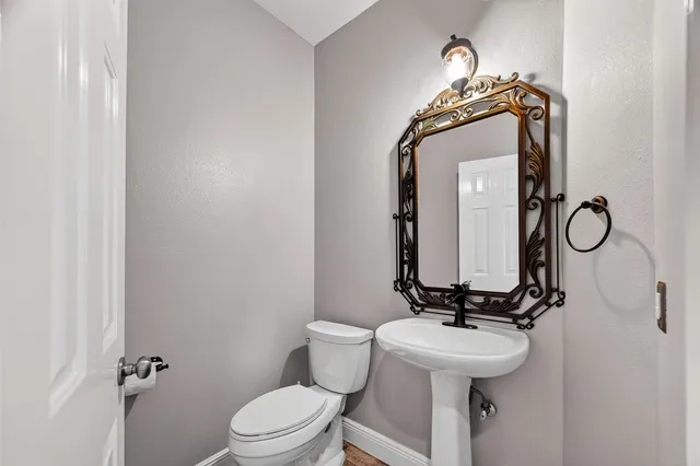 a bathroom with a toilet sink and mirror