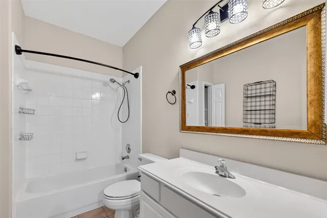 a bathroom with a granite countertop sink a toilet and shower