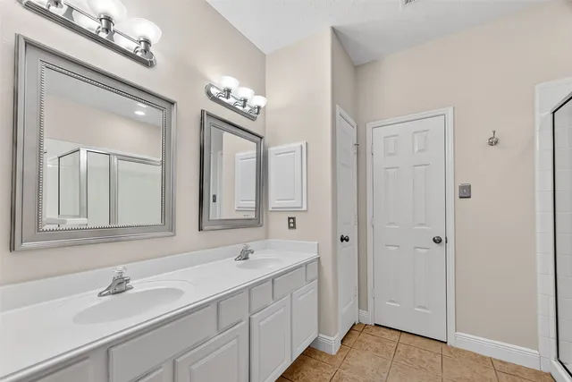 a bathroom with double vanity sinks a vanity a mirror and a shower