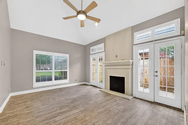 wooden floor fireplace and windows in an empty room