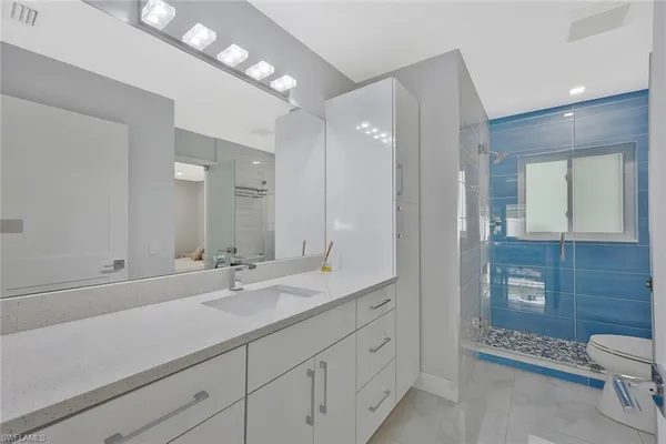 a bedroom with a large bed and a flat tv screen on dresser