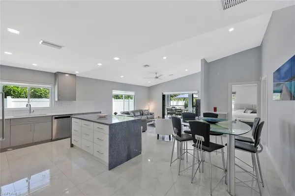 a kitchen with stainless steel appliances kitchen island granite countertop a table and chairs in it