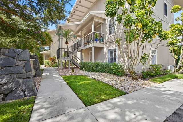 a view of a white house with a yard and plants