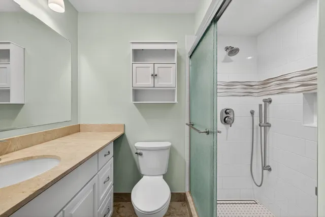 a bathroom with a granite countertop sink toilet and shower