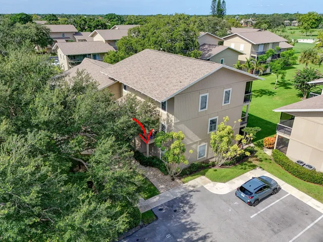 an aerial view of residential houses with outdoor space and trees