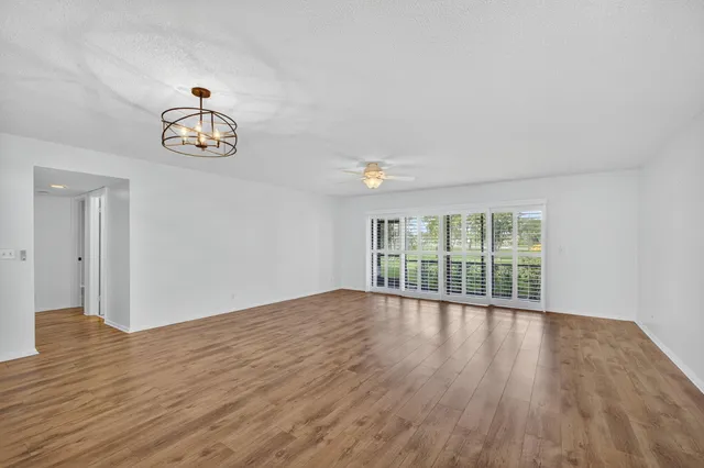 an empty room with wooden floor and window