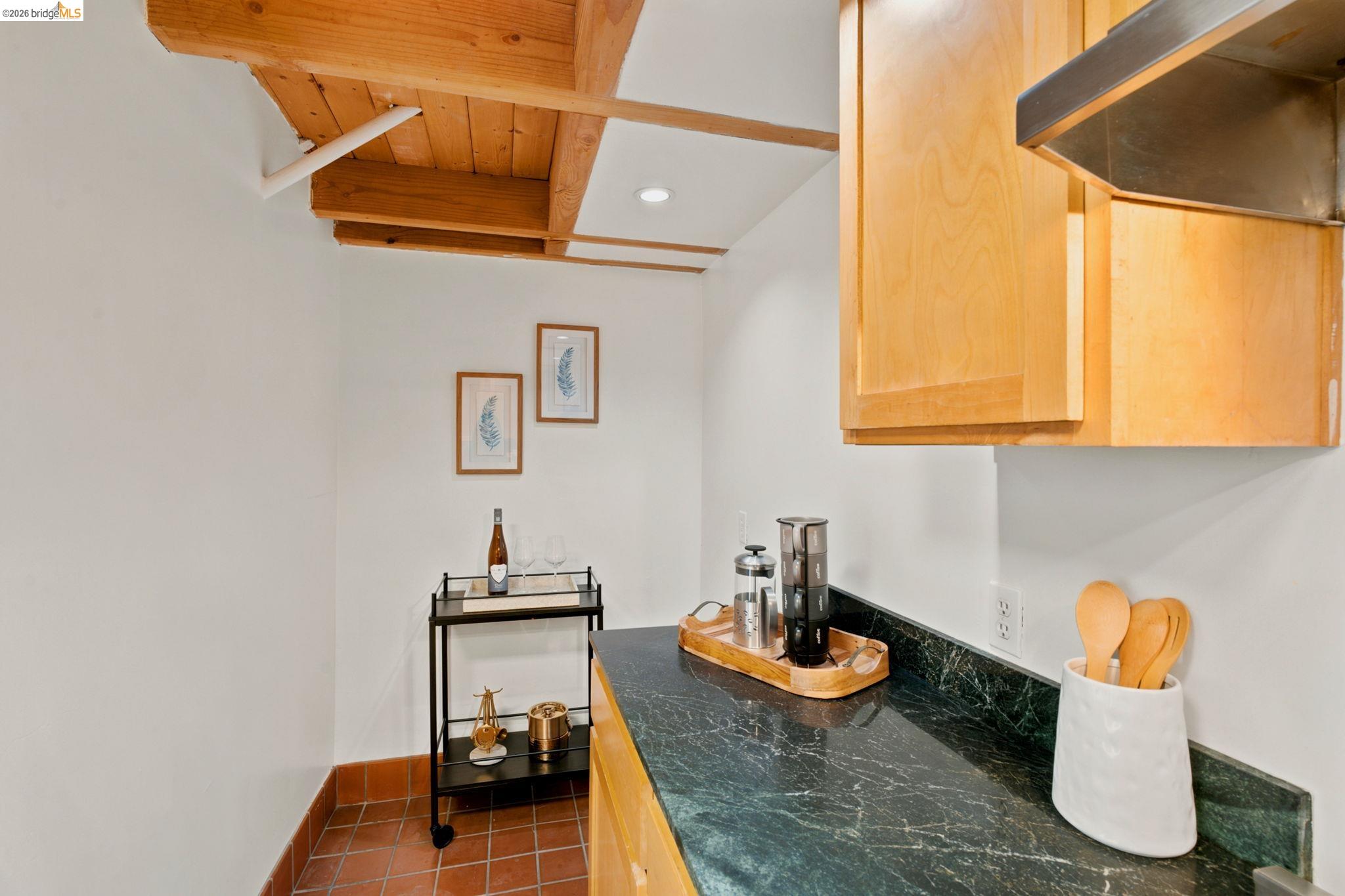 1920 Union Street, Unit 9 Oakland, CA 94607 - Photo 17 of 35 Kitchenette featuring wood-finish cabinetry, a dark countertop, and exposed wood ceiling beams