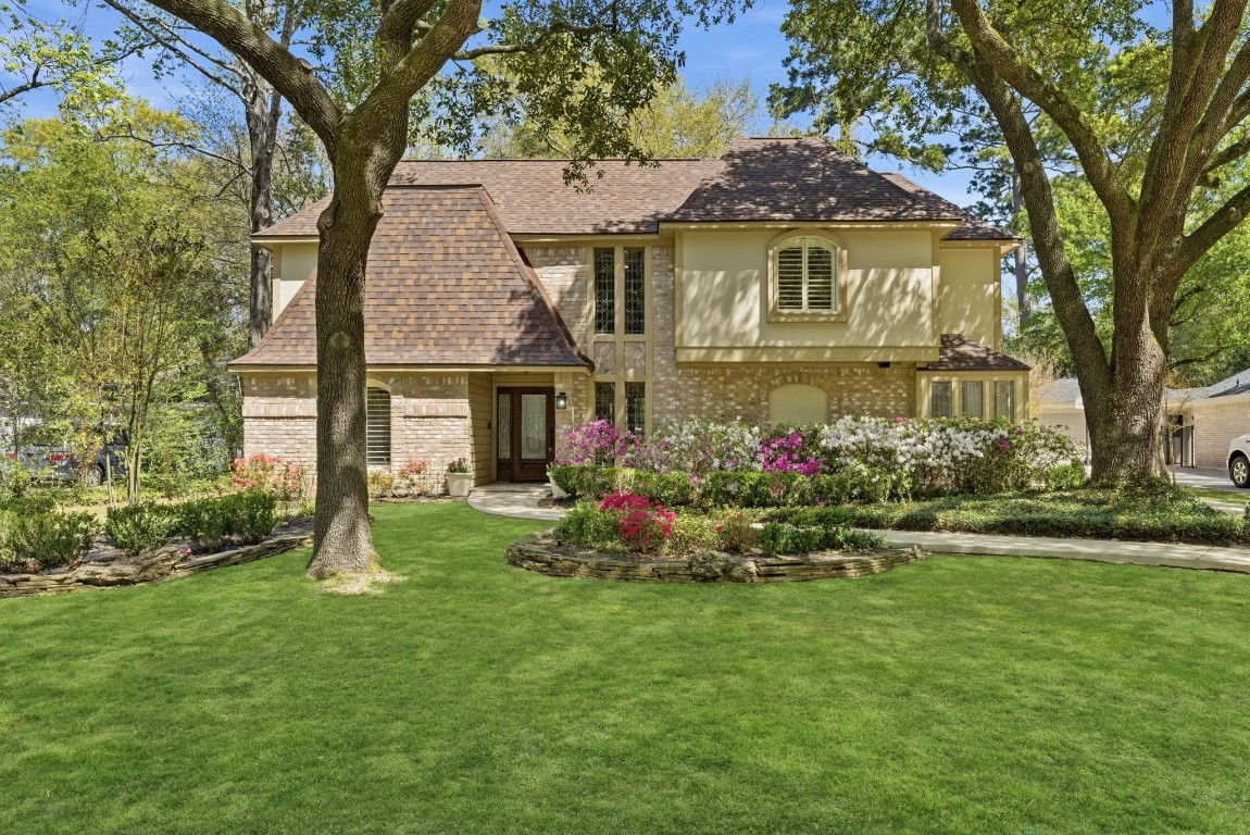 20 Falling Star Road The Woodlands, TX 77381 - Photo 1 of 44 This charming two-story home features a brick exterior with a warm, inviting facade. Nestled among mature trees, it boasts a well-manicured lawn and colorful flower beds, creating excellent curb appeal.