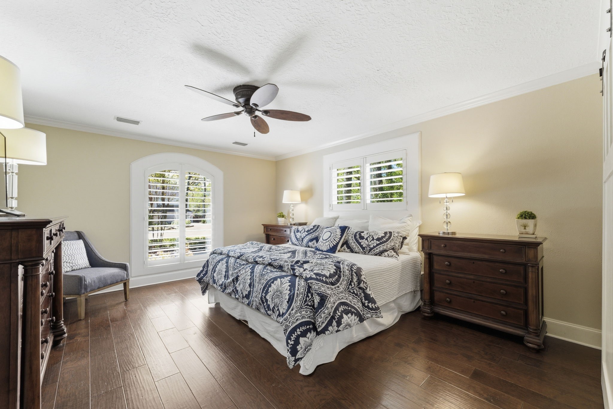 20 Falling Star Road The Woodlands, TX 77381 - Photo 20 of 44 The primary bedroom features hardwood floors, a ceiling fan, and abundant natural light from two windows with shutters.