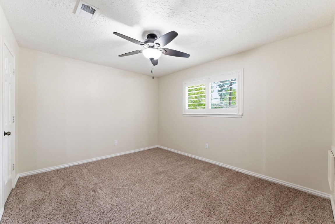 20 Falling Star Road The Woodlands, TX 77381 - Photo 33 of 44 Secondary bedroom #3 is bright and cozy room with neutral walls, carpeted flooring, a ceiling fan, and a window with plantation shutters.