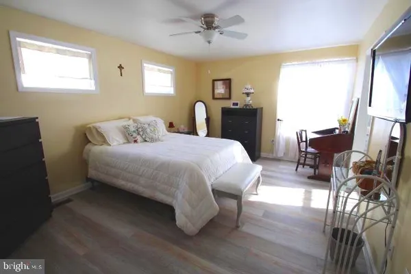 a spacious bedroom with a bed and wooden floor