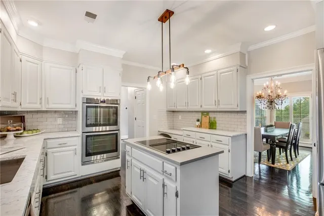 a kitchen with white cabinets and appliances