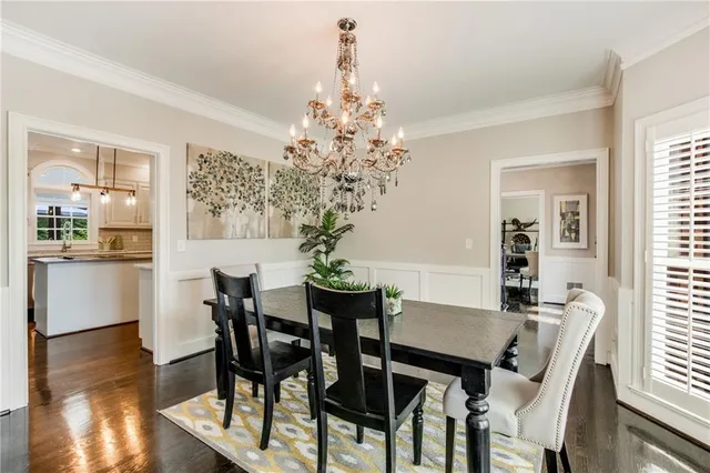 a dining room with furniture potted plants and wooden floor