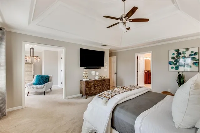 a bedroom with a bed a flat screen tv and a couch