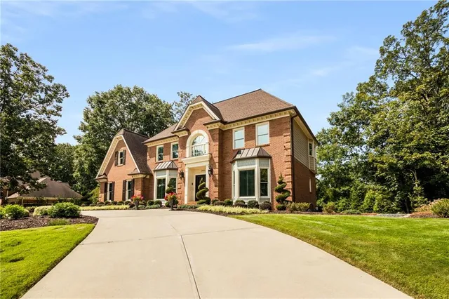 a front view of a house with yard and green space