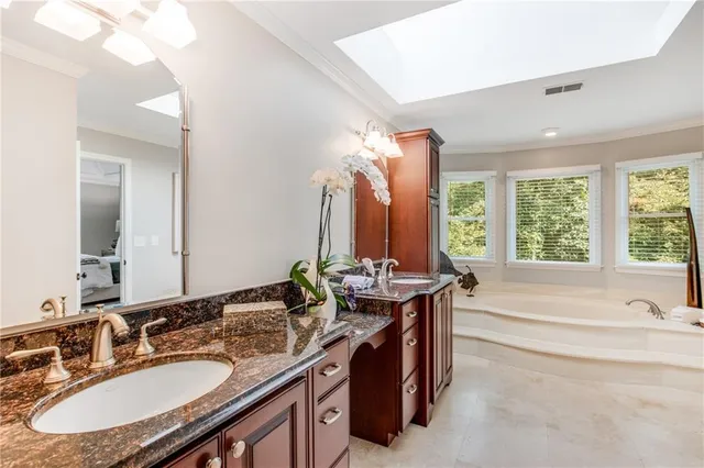 a bathroom with a granite countertop sink and a bathtub