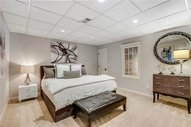 a bedroom with a bed a mirror on dresser and a window