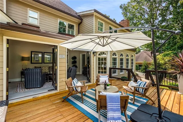 a view of a patio with couches table and chairs under an umbrella