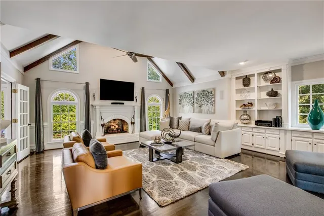 a living room with furniture fireplace and a large window