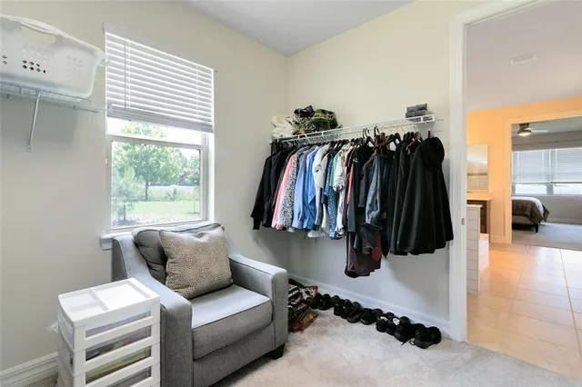 a walk in closet with clothes and shoes