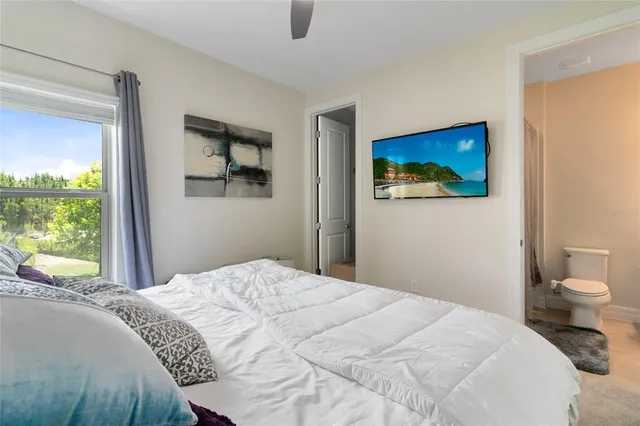 a bedroom with a bed and a painting on the wall
