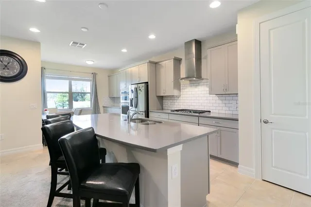 a kitchen with stainless steel appliances granite countertop a sink and a refrigerator