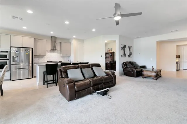a living room with furniture and a refrigerator