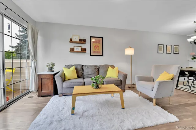 a living room with furniture and a table with wooden floor