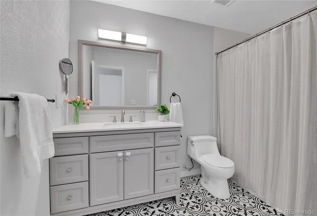 a bathroom with a sink a toilet and a mirror