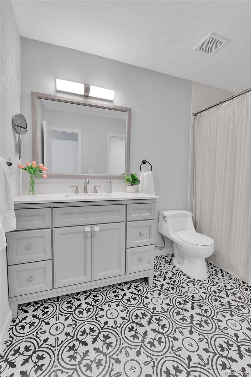 1818 South Quebec Way, Unit 46 Denver, CO 80231 - Photo 20 of 34 a bathroom with a sink toilet and a mirror