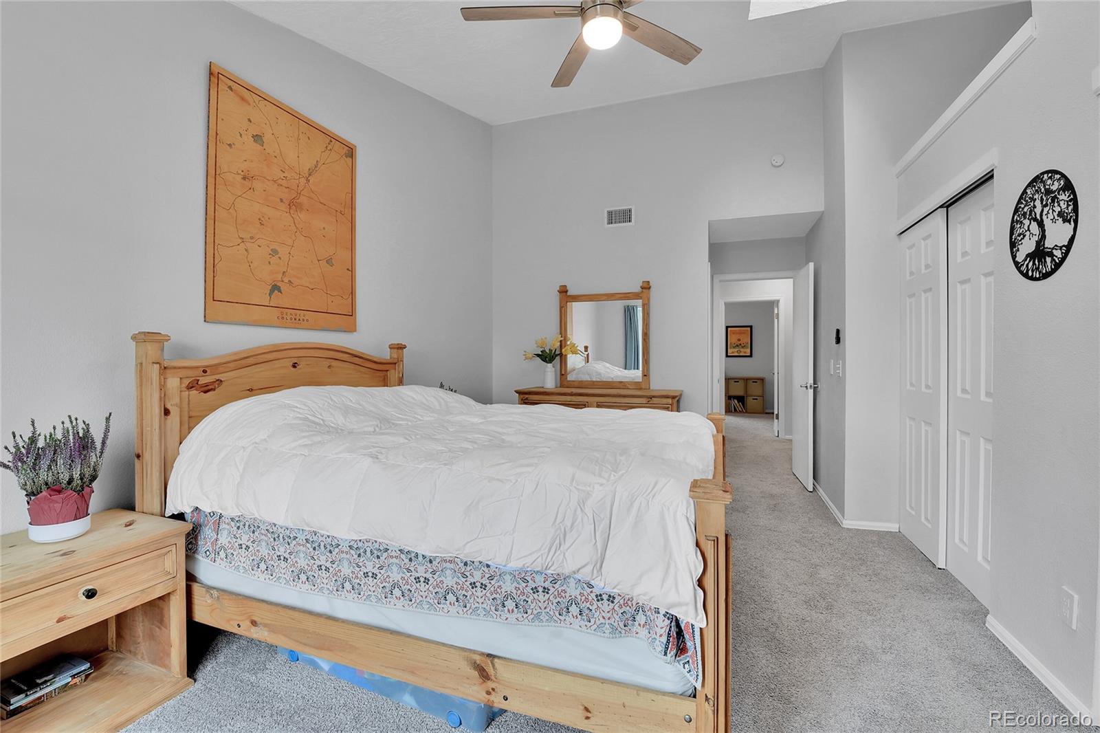 1818 South Quebec Way, Unit 46 Denver, CO 80231 - Photo 24 of 34 a bedroom with a bed and a chandelier