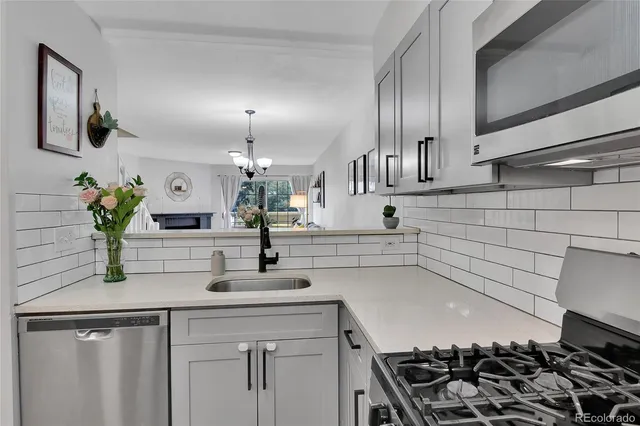 a kitchen with granite countertop a sink stove and cabinets