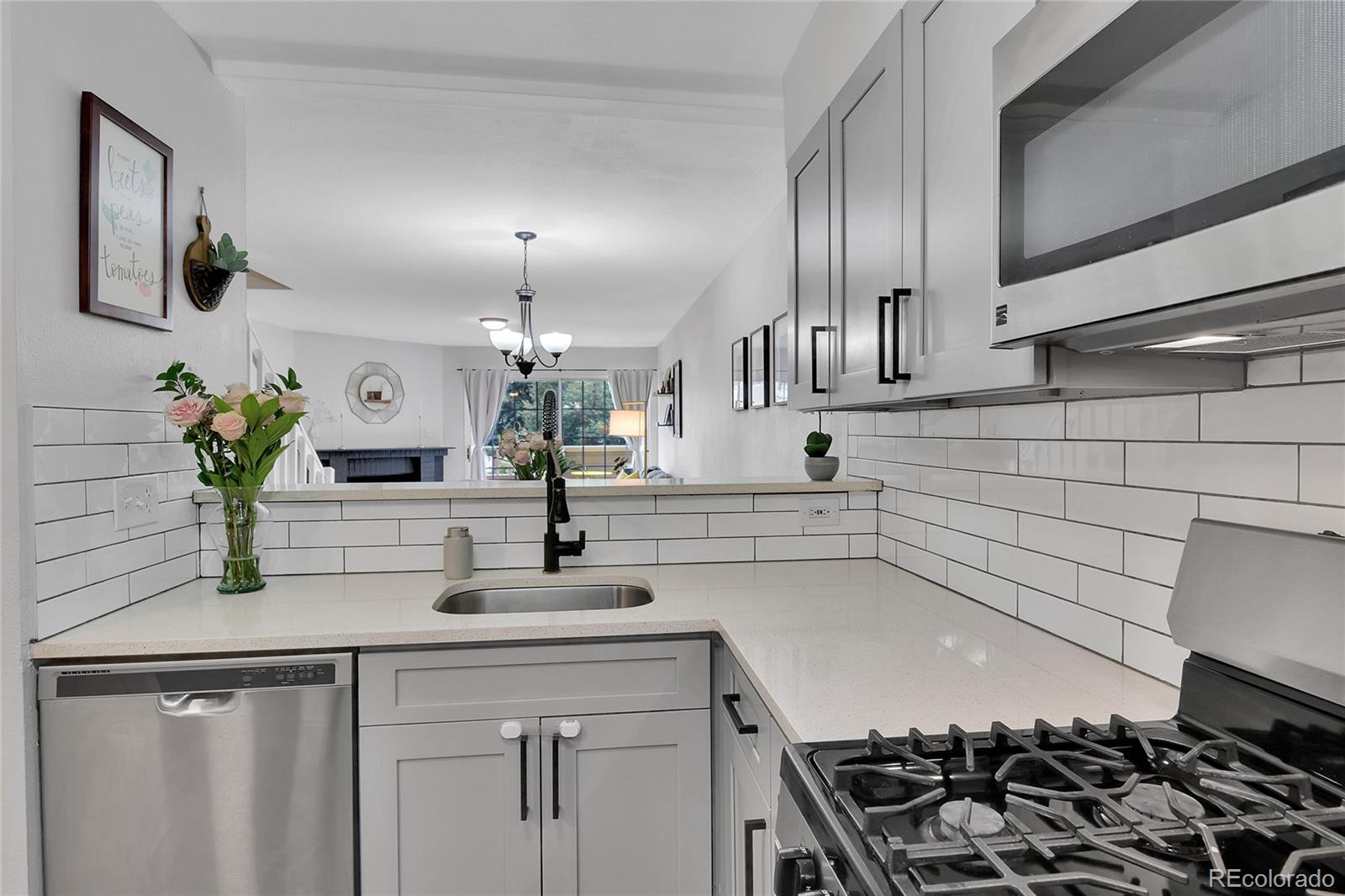 1818 South Quebec Way, Unit 46 Denver, CO 80231 - Photo 3 of 34 a kitchen with granite countertop a sink stove and cabinets