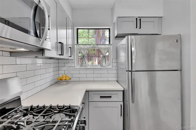 a kitchen with a refrigerator and a stove