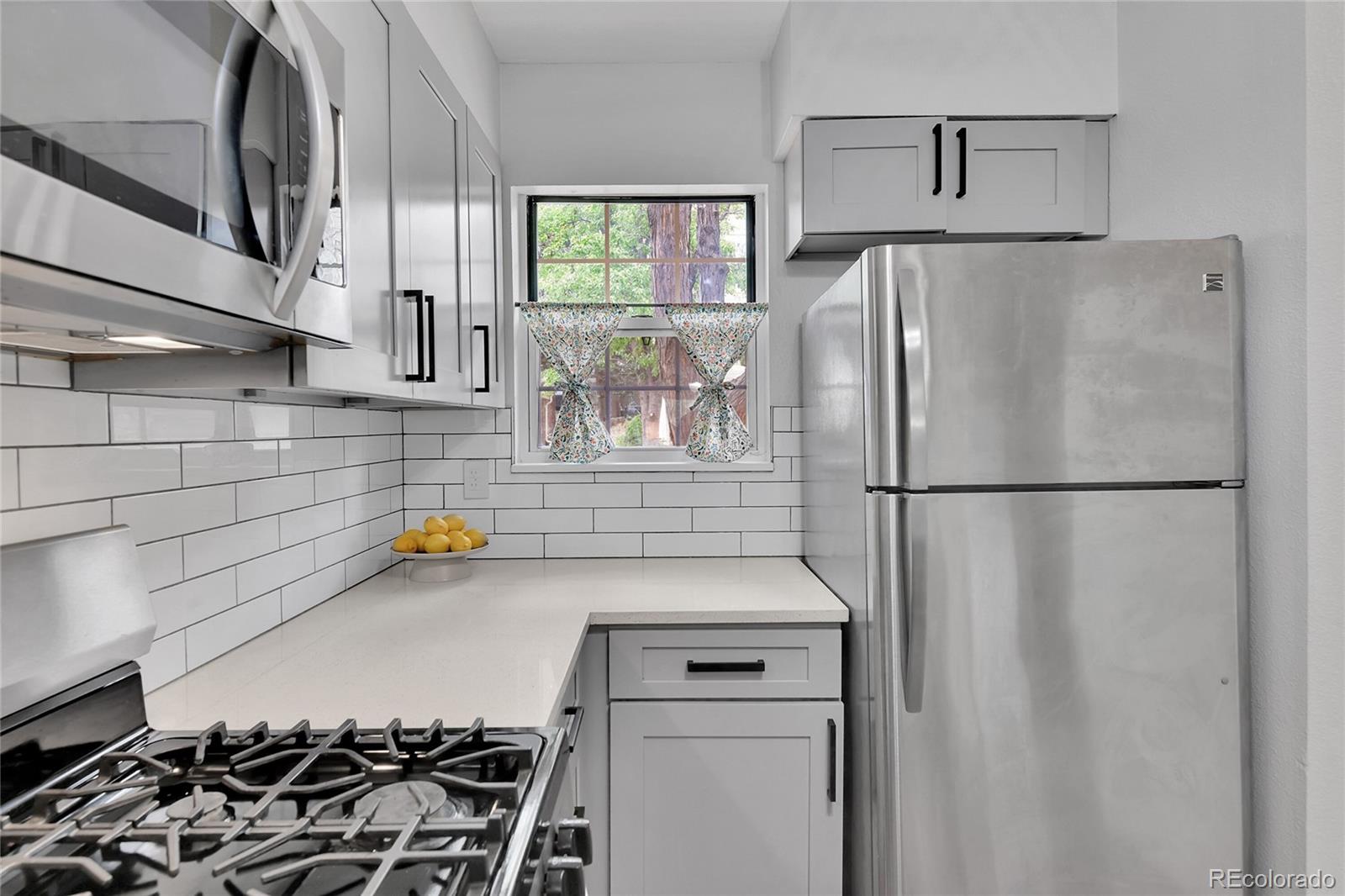 1818 South Quebec Way, Unit 46 Denver, CO 80231 - Photo 5 of 34 a kitchen with a refrigerator and a stove